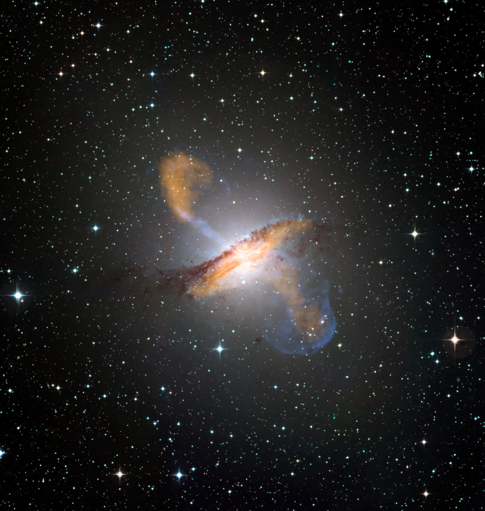 Colour composite image of Centaurus A, revealing the lobes and jets emanating from the active galaxy’s central black hole. This is a composite of images obtained with three instruments, operating at very different wavelengths. The 870-micron submillimetre data, from LABOCA on APEX, are shown in orange. X-ray data from the Chandra X-ray Observatory are shown in blue. Visible light data from the Wide Field Imager (WFI) on the MPG/ESO 2.2 m telescope located at La Silla, Chile, show the stars and the galaxy’s characteristic dust lane in close to "true colour".